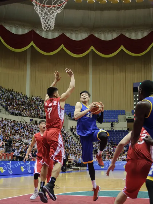Pemain Korea Selatan (Biru) berusaha memasukan bola ke dalam ring saat bertanding melawan Korea Utara (merah) selama pertandingan basket pria di Stadion Indoor Ryugyong Chung Ju-Yung, Pyongyang (5/7). (AFP Photo/Kim Won-Jin)