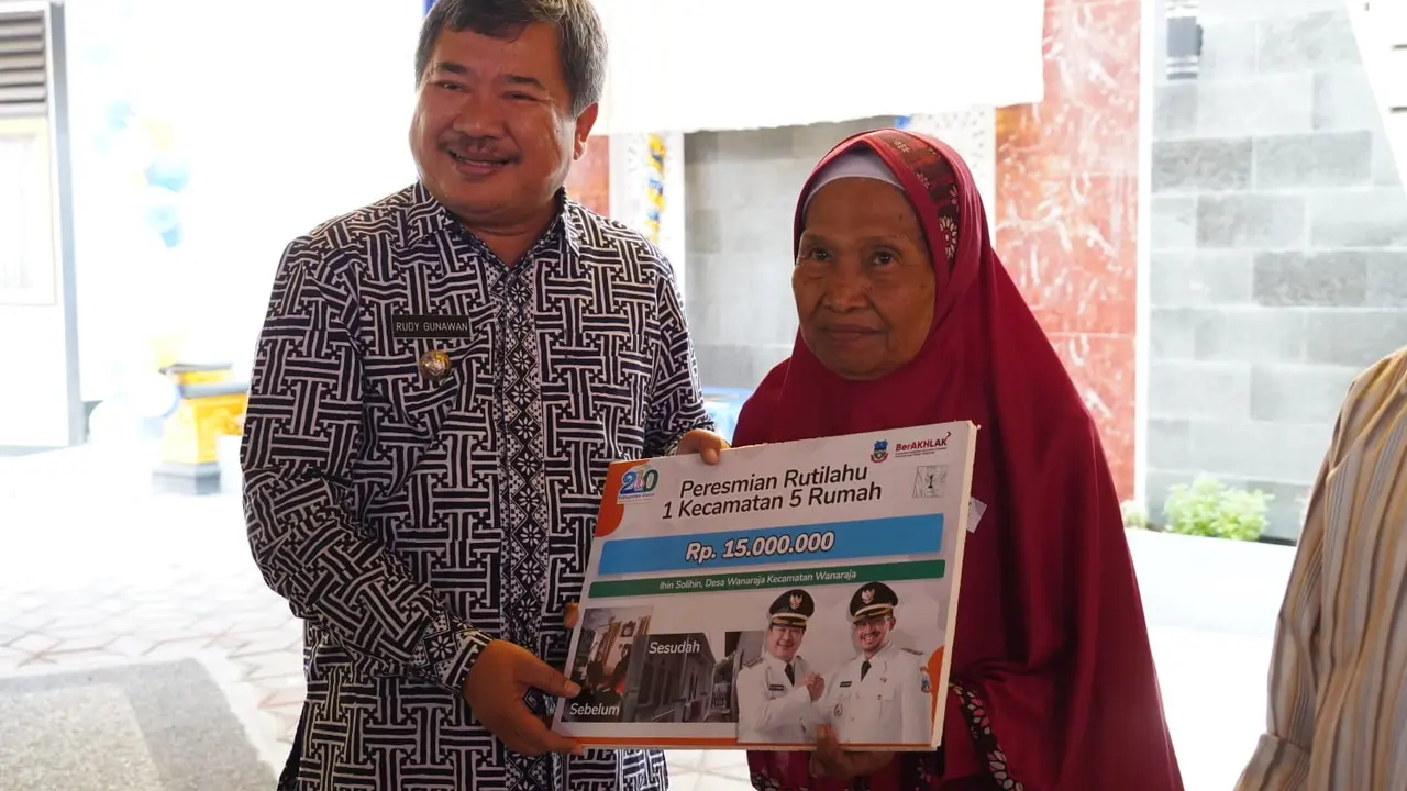 Bupati Garut Rudy Gunawan memberikan simbolis pemberikan bantuan program rutilahu bagi salah seorang warga penerima dari 442 desa dan kelurahan di Garut. (Liputan6.com/Jayadi Supriadin)