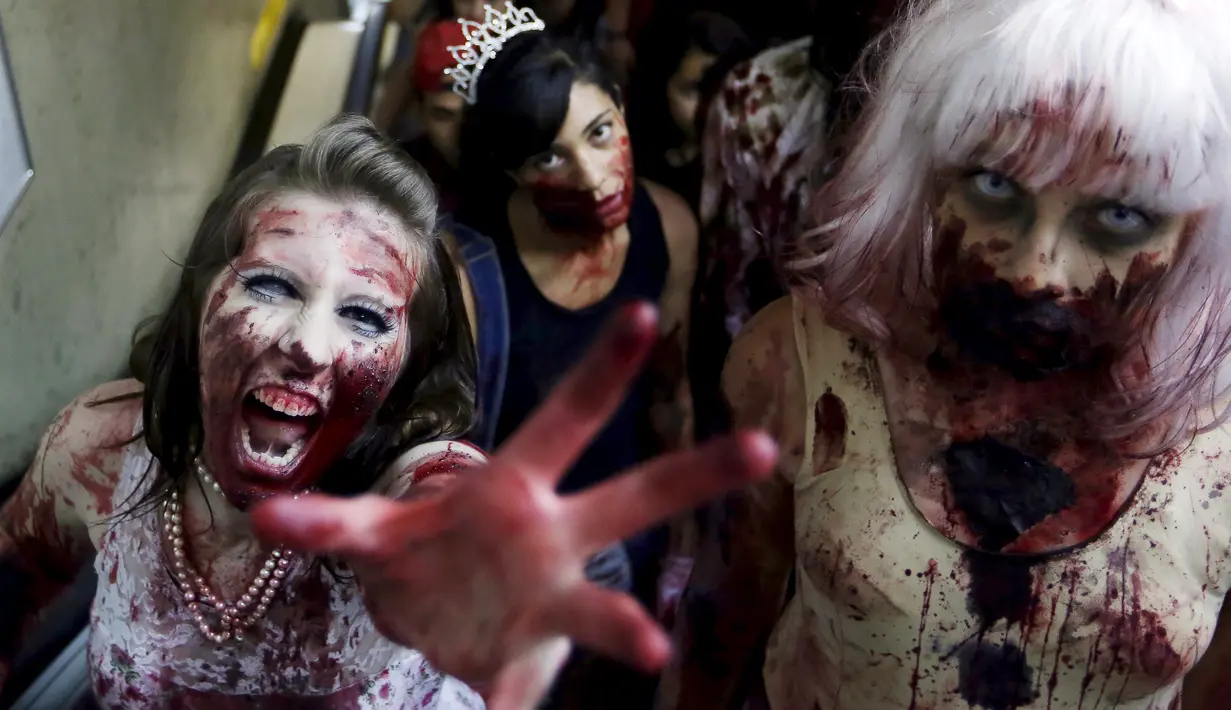 Sejumlah gadis berkostum zombie menaiki eskalator di stasiun metro sebelum mengikuti parade "Zombie Walk" di Sao Paulo, Brasil, Senin (2/11/2015). (REUTERS / Paulo Whitaker)