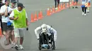 Raechana Syafei (45 tahun) memacu kursi roda dan sampai di garis finish dengan waktu 2 jam 15 menit dengan jarak lari 10 km. (Liputan6.com/Andrian M. Tunay)