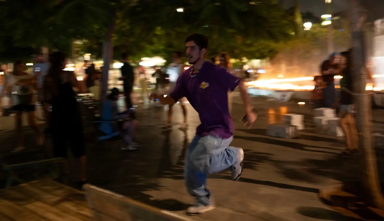 Seorang anak laki-laki berlari mencari perlindungan saat sirene membunyikan peringatan akan adanya roket di Alun-Alun Dizengoff, Tel Aviv, Israel, Rabu (18/10/2023). (AP Photo/Petros Giannakouris)