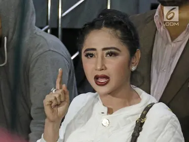 Pedangdut Dewi Persik menjawab pertanyaan awak media seusai membuat laporan di Polda Metro Jaya, Jakarta, Senin (4/12). Dewi Persik melapor balik petugas TransJakarta, Harry Maulana Saputra atas pencemaran nama baik. (Liputan6.com/Herman Zakharia)