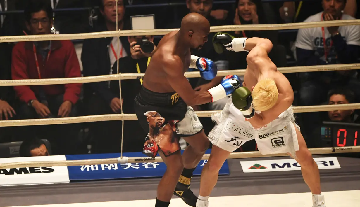Petinju, Floyd Mayweather, beradu pukulan dengan kickboxer, Tenshin Nasukawa, pada laga eksebisi di Saitama Super Arena, Saitama, Senin (31/1). Tanding dengan aturan tinju, Mayweather menang TKO di ronde pertama. (AFP/Toshifumi Kitamura)