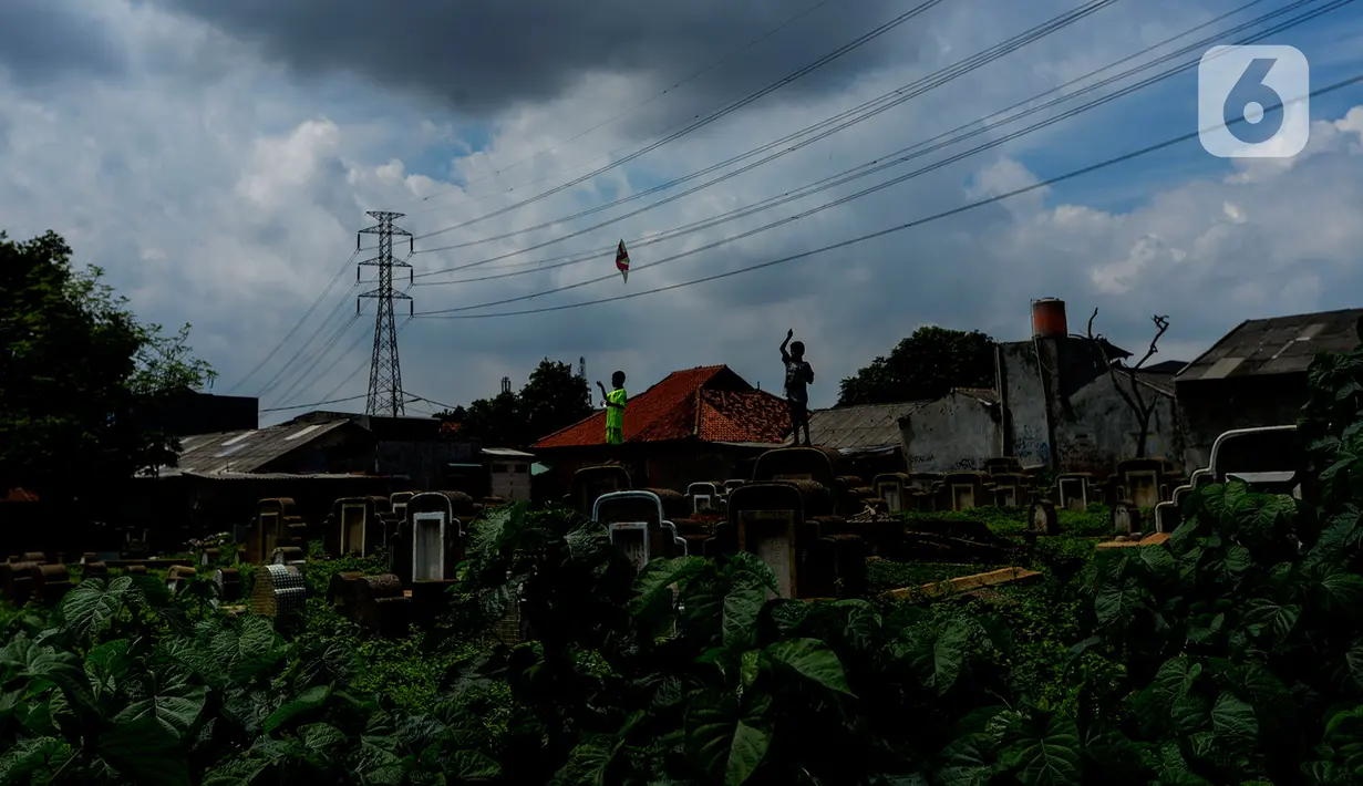 Anak-anak menerbangkan layang-layang di Tanah Makam Cipinang Besar Utara, Jakarta, Selasa (14/1/2020). Pemprov DKI Jakarta berencana terus menambah Ruang Publik Terpadu Ramah Anak (RPTRA) di sejumlah wilayah. (merdeka.com/Imam Buhori)