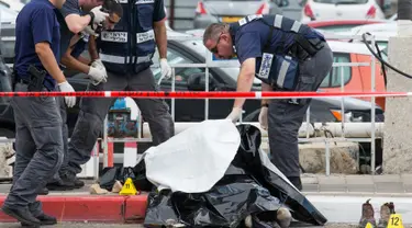 Polisi Israel memeriksa mayat pria Palestina yang ditembak mati usai menikam dua warga Israel di Tel Aviv, Kamis (8/10). Menurut juru bicara polisi Israel, pria Palestina itu menikam tentara wanita dengan obeng di Mulailah Street. (AFP PHOTO/JACK GUEZ)