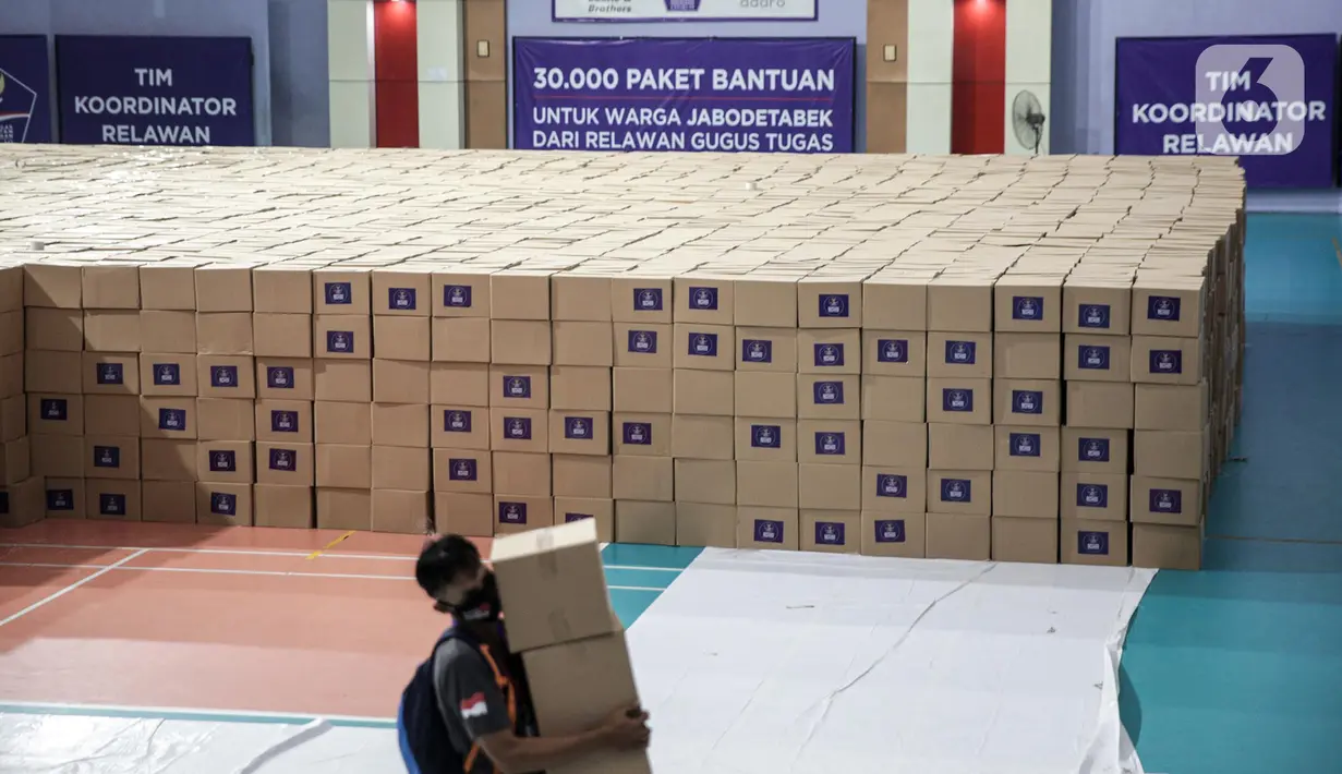 Relawan Gugus Tugas Percepatan Penanganan COVID-19 memindahkan kotak berisi sembako di GOR Gelanggang Remaja, Jakarta, Senin (18/5/2020). Relawan Gugus Tugas Percepatan Penanganan COVID-19 membagikan 30.000 paket bantuan kepada warga Jabodetabek yang terdampak COVID-19. (Liputan6.om/Faizal Fanani)