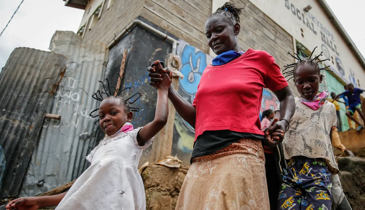 Margaret Andeya membawa anak (kanan) dan putri tetangganya pulang setelah rambutnya ditata dengan model corona Covid-19 di daerah kumuh Kibera, di Kenya, 3 Mei 2020. Corona telah menghidupkan kembali gaya rambut di Afrika Timur yang memiliki lonjakan kepang bentuk khas virus (AP/Brian Inganga, File)