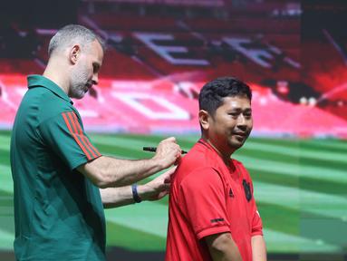 Legenda Manchester United (MU), Ryan Giggs, membubuhkan tanda tangan di jersey fans dalam acara peluncuran kartu kredit Maybank yang berkolaborasi dengan MU di Jakarta Convention Center (JCC), Senayan, Jakarta, Sabtu (18/5/2024). (Bola.com/M Iqbal Ichsan)