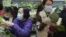 Pelanggan mengenakan masker, membeli sayuran segar di toko pasar basah di Hong Kong, Rabu, 9 Februari 2022. Hong Kong memberlakukan langkah-langkah jarak sosial yang paling ketat untuk mempertahankan kebijakan nol COVID-19 di tengah lonjakan kasus yang dipicu Varian Omicron. (AP Photo/Vincent Yu)