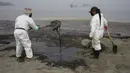 Pekerja mengenakan pakaian pelindung membersihkan Pantai Conchitas yang terkontaminasi tumpahan minyak, di Ancon, Peru, Kamis (20/1/2022). Tumpahan minyak di pantai Peru disebabkan oleh gelombang dari letusan gunung berapi bawah laut di negara Pasifik Selatan Tonga. (AP Photo/Martin Mejia)