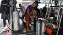 Penyelam memeriksa tangki oksigen saat bersiap melanjutkan pencarian korban kapal wisata yang terbalik di dermaga Chalong, Phuket, Sabtu (7/7). Sebanyak 56 penumpang dilaporkan hilang pada Jumat pagi sebelum upaya penyelamatan dimulai. (AFP/Mohd RASFAN)