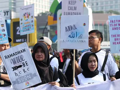 Sejumlah remaja mengangkat tulisan menyambut datangnya bulan Ramadan saat acara Car Free Day di Kawasan Bundaran Hotel Indonesia, Jakarta, Minggu (13/5). Mereka mengajak warga untuk menyambut bulan suci bagi umat muslim. (Liputan6.com/Helmi Fithriansyah)