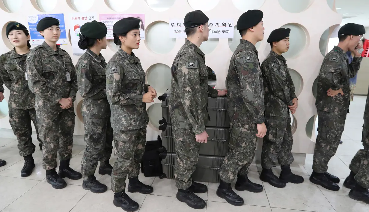 Sejumlah tentara Korsel mengantre untuk memberikan hak suaranya pada pemilihan presiden (Pilpres) di sebuah TPS di Seoul, Kamis (4/5). Mereka dapat memberikan suara di TPS di mana saja tidak terikat pada tempat tinggal mereka. (AP Photo/Lee Jin-man)