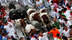 Sejumlah banteng mengejar para peserta dalam festival San Fermin di Pamplona, Spanyol utara, (9/7). Dalam festival ini peserta banyak yang mengalami luka memar terkena tusukkan tanduk banteng. (REUTERS/Susana Vera)