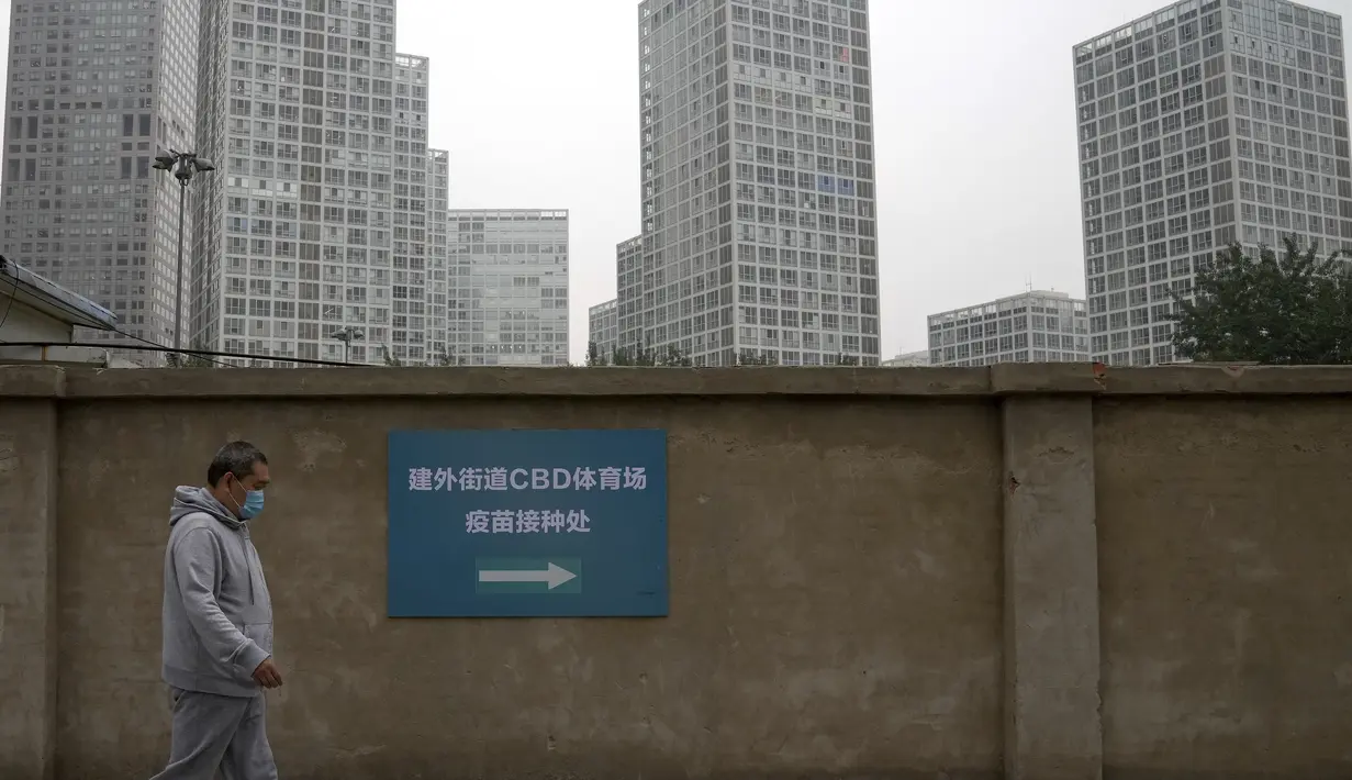 Seorang pria yang berjalan ke pusat vaksinasi untuk menerima vaksin Sinopharm COVID-19 di Central Business District di Beijing, Rabu (2/6/2021).Vaksin itu disebut sudah menyebar sebanyak jutaan dosis, baik diberikan ke penduduk "Negeri Panda" maupun negara lain. (AP Photo/Andy Wong)