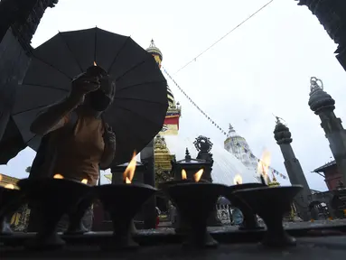 Umat Buddha berdoa di Stupa Swayambhunath pada acara Festival Buddha Purnima, selama lockdown virus corona yang diberlakukan pemerintah, di Kathmandu, Nepal, Rabu (26/5/2021). Waisak disebut juga Buddha Purnima atau Buddha Jayanti. (PRAKASH MATHEMA / AFP)