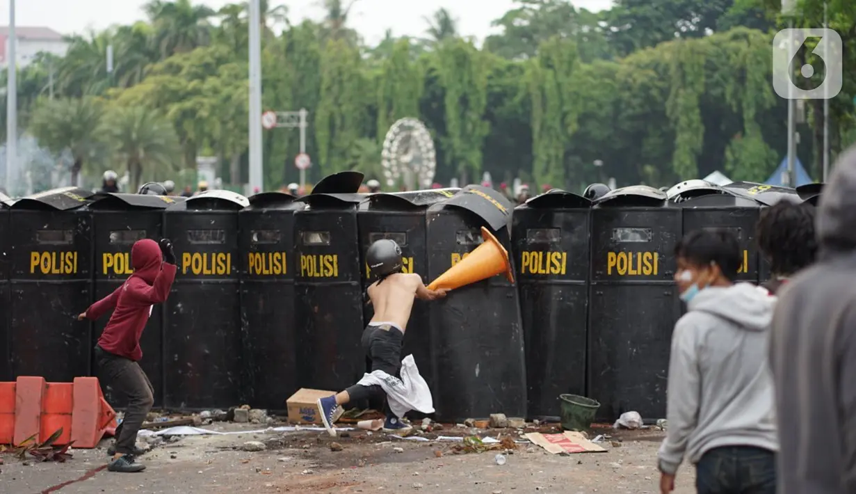 Pengunjuk rasa terlibat bentrok dengan polisi di Jalan Medan Merdeka Timur, Jakarta, Kamis (8/10/2020). Bentrokan terjadi akibat massa yang memaksa masuk ke depan Istana Negara untuk berunjuk rasa terkait penolakan UU Cipta Kerja. (Liputan6.com/Immanuel Antonius)