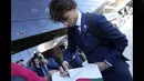 Lantas ada juga pemain Atletico Madrid, Joao Felix yang membubuhkan tanda tangan pada jersey Timnas Portugal yang dibawanya. (AP Photo/Armando Franca)