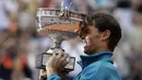 Rafael Nadal mengangkat trofi Prancis Terbuka 2018 setelah mengalahkan petenis Austria, Dominic Thiem pada final di Roland Garros stadium, Paris, (10/6/2018). Nadal menang tiga set 6-4, 6-3, 6-2. (AP/Alessandra Tarantino)