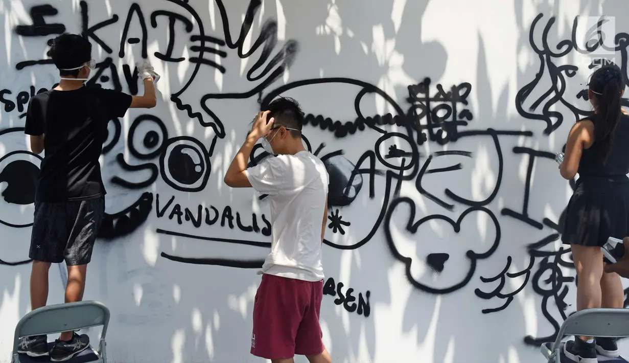 Siswa sedang melukis mural di dinding sekolah JIS, Jakarta, Sabtu (7/4). Siswa juga dapat memahami cara pandang dan mempelajari bagaimana proses seorang seniman yang konsisten fokus menghasilkan sebuah karya seni visual art. (Liputan6.com/Herman Zakharia)
