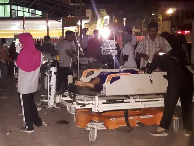 Sejumah perawat, dokter dan pasien berada diluar rumah sakit saat gempa mengguncang Lombok Utara, NTB Minggu malam (5/8). Gempa berada pada titik 8.25 LS, 116.49 BT, atau sekitar 27 km Timur Laut Lombok Utara, NTB. (AFP Photo/Rita Siswati)