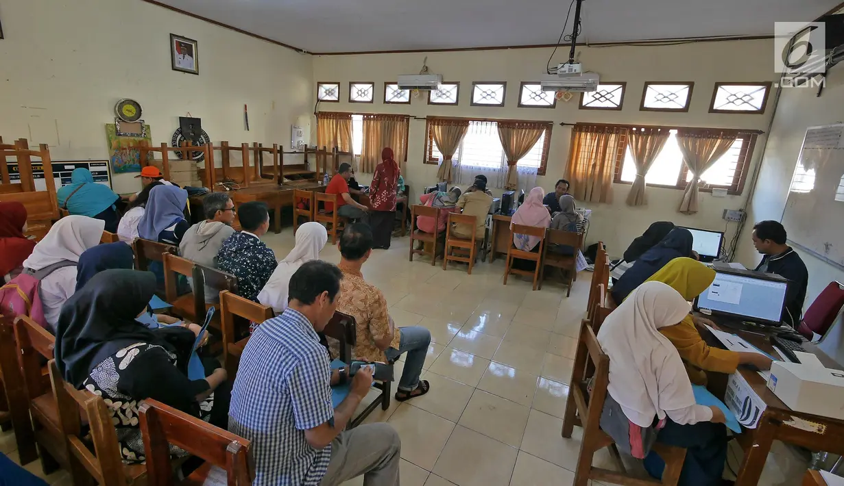 Suasana saat orangtua murid saat mengisi kelengkapan seleksi Penerimaan Peserta Didik Baru (PPDB) di SMAN 1 Depok,  Kota Depok, Jawa Barat, Selasa (18/6/2019). Sistem PPDB Jawa Barat berlangsung pada tanggal 17-22 Juni 2019. (Liputan6.com/Herman Zakharia)