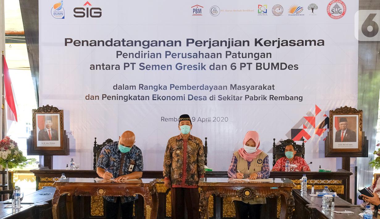 Dirut PT Semen Gresik, Mukhamad Saifudin (kiri), Direktur BUMDes PT Indo Kadiwono Sukses, Uswatun Khasanah (kanan) menandatangani Perjanjian Kerjasama Pendirian Perusahaan Patungan antara PT Semen Gresik dengan 6 PT BUMDes di Rembang, Kamis (9/4/2020). (Liputan6.com/Pool/SIG)