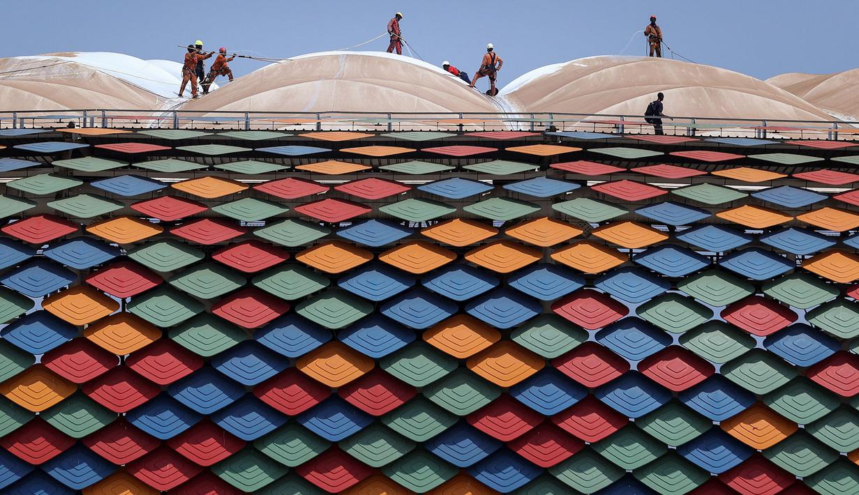 Sejumlah pekerja sedang mempersiapkan fasilitas Stadion Olembe yang terletak di Yaounde, pada 7 Januari 2022. Stadion yang berkapasitas 60.000 penonton tersebut rencananya akan digunakan untuk venue pembukaan Piala Africa 2021. (AFP/Kenzo Tribouillard).