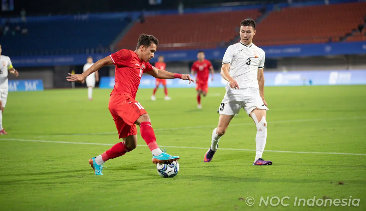 <p>Pemain Timnas Indonesia U-24 Egy Maulana Vikri menggiring bola mencoba melewati pemain Timnas Kirgistan Elaman Akylbekov pada pertandingan sepak bola putra Grup F Asian Games 2023 di Zhejiang Normal University East Stadium, Jinhua, China, Selasa (19/9/2023). Indonesia menang 2-0 atas Kirgistan. (Kredit Foto: NOC Indonesia/Naif Al&rsquo;As)</p>