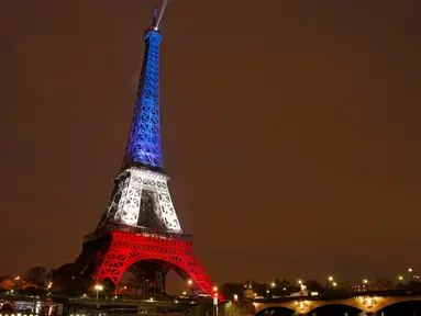 Menara Eiffel pada Senin (16/11), dihiasi lampu berwarna bendera Prancis untuk menghormati para korban serangan teror di Paris hari Jumat (13/11) lalu. Menara Eiffel dan sejumlah tempat kebudayaan sempat ditutup selama dua hari. (REUTERS/Benoit Tessier)
