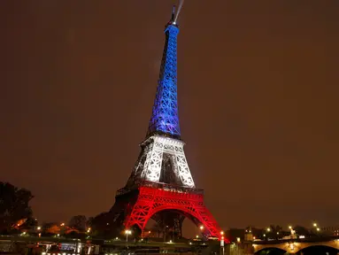 Menara Eiffel pada Senin (16/11), dihiasi lampu berwarna bendera Prancis untuk menghormati para korban serangan teror di Paris hari Jumat (13/11) lalu. Menara Eiffel dan sejumlah tempat kebudayaan sempat ditutup selama dua hari. (REUTERS/Benoit Tessier)