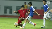 Kapten Timnas Indonesia U-16, Kartika Vedayanto Putra (kiri) mencoba melewati kawalan pemain Singapura U-16 saat laga persahabatan di Stadion Wibawa Mukti, Kab Bekasi, Kamis (8/6). Indonesia U-16 menang telak 4-0. (Liputan6.com/Helmi Fithriansyah)