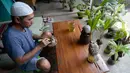 Seniman, Herman Ronda (49) mengukir bibit pohon kelapa yang dijadikan bonsai di Pondok Benda Pamulang, Tangerang Selatan, Selasa (13/10/2020). Budidaya bonsai tanaman kelapa semakin digemari untuk memanfaatkan waktu dengan harga mulai dari Rp 250 ribu hingga Rp 500 ribu. (merdeka.com/Dwi Narwoko)