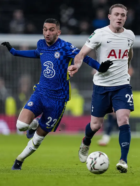 Gelandang Chelsea, Hakim Ziyech berebut bola dengan pemain Tottenham, Oliver Skipp pada leg kedua semifinal Piala Liga Inggris di Stadion Tottenham Hotspur di London, Kamis (13/1/2022). Ini adalah kali pertama Chelsea melaju ke final Piala Liga Inggris sejak 2019. (AP Photo/Alastair Grant)
