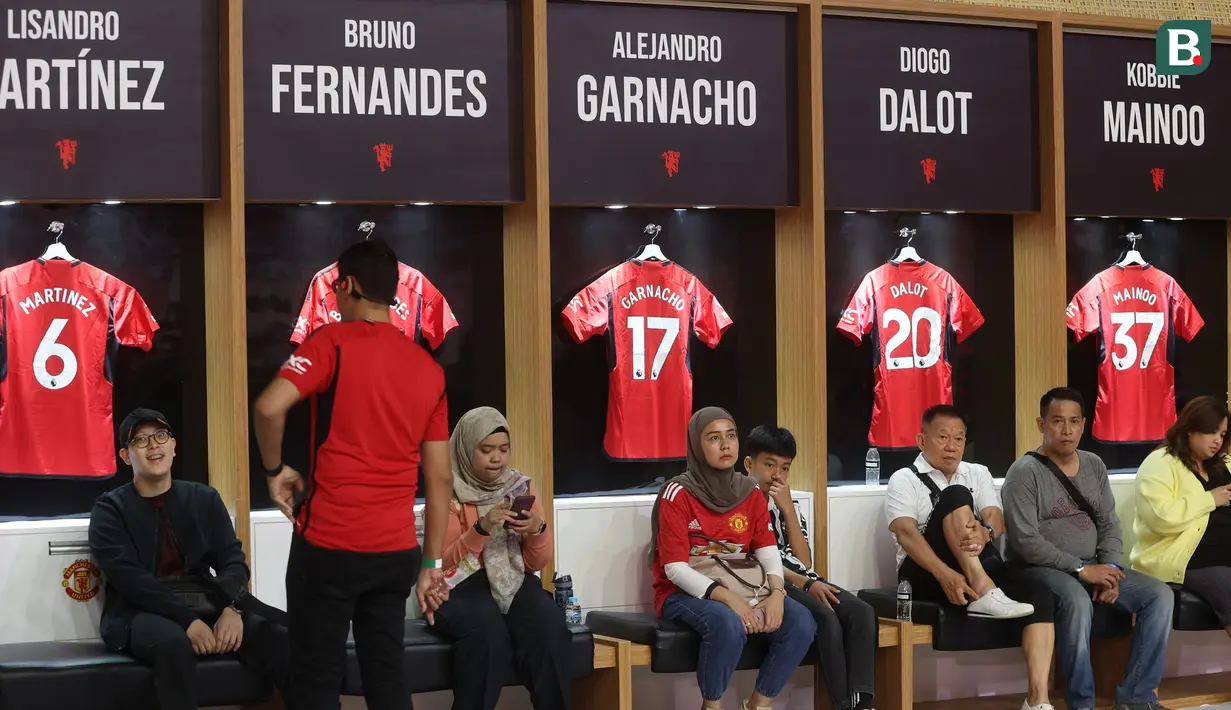 Beberapa fans menikmati suasana replika ruang ganti pemain Stadion Old Trafford dalam acara peluncuran kartu kredit Maybank bersama Ryan Giggs yang berkolaborasi dengan Manchester United di Jakarta Convention Center (JCC), Senayan, Jakarta, Sabtu (18/5/2024). (Bola.com/M Iqbal Ichsan)