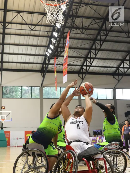 Pebasket difable Indonesia, Kasep Ayatulloh (tengah) mencoba melempar bola ke ring saat laga melawan Malaysia pada laga Indonesia Para Games Invitational Tournament 2018 di Hall A Senayan, Jakarta, Minggu (1/7). (Liputan6.com/Helmi Fithriansyah)