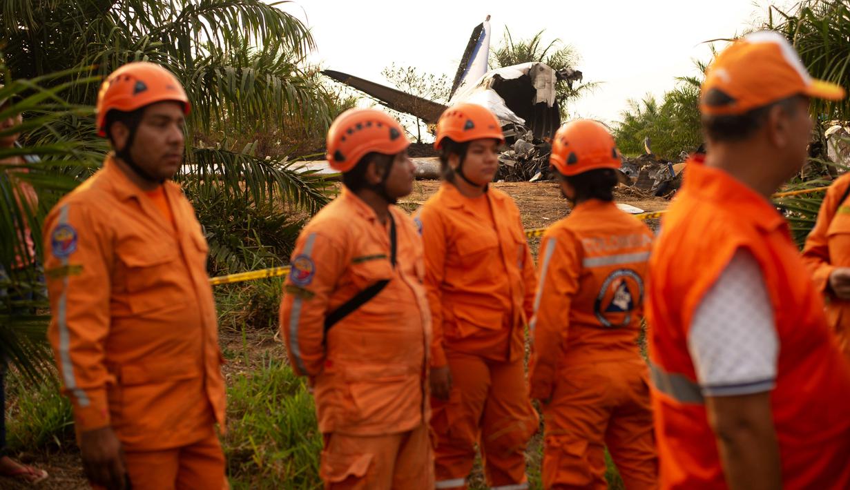 Petugas pertahanan sipil Kolombia bersiap mengevakuasi Puing pesawat penumpang Douglas DC-3 yang jatuh di provinsi dataran Kolombia, Meta, San Martin, Kolombia (9/3). Sebanyak 12 penumpang di dalamnya tewas. (Reuters/Santiago Molina)