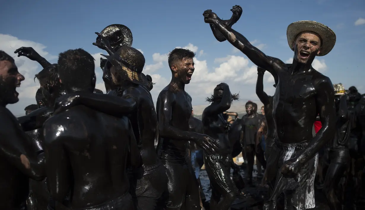 Para peserta dengan tubuh dilumuri minyak hitam mengikuti Festival Tradisionlal Cascamorras di Baza, Granada, Spanyol (6/9/2019). Festival ini diadakan setiap tanggal 6 September dan telah berlangsung selama 500 tahun terakhir. (AFP Photo/Jorge Guerrero)