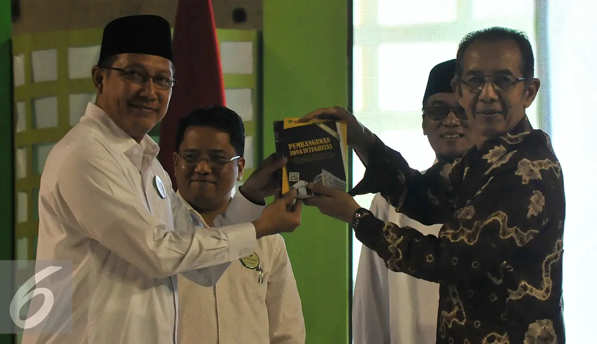 Menag, Lukman Hakim Saifuddin dan Wakil Ketua KPK Zulkarnain memperlihatkan buku usai acara Penandatanganan komitmen berintegritas, Jakarta, Senin (15/6/2015). (Liputan6.com/Johan Tallo)