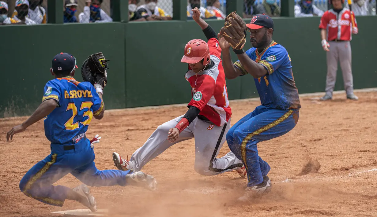 M. Rizki dari DKI Jakarta sliding di home base pada pertandingan kedua babak penyisihan softball putra PON XX Papua antara DKI Jakarta vs Papua Barat di Lapangan Softball Uncen, Kota Jayapura, Rabu (22/09/2021). (Foto : PB PON XX PAPUA/Robertus Pudyanto)