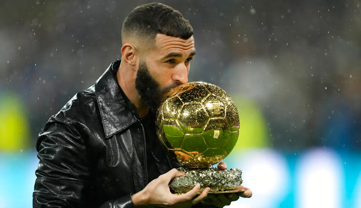 Pemain Real Madrid Karim Benzema mencium trofi Ballon d'Or 2022 sebelum pertandingan sepak bola Liga Spanyol antara Real Madrid dan Sevilla di Stadion Santiago Bernabeu, Madrid, Spanyol, 22 Oktober 2022. Gelar Ballon d’Or ini merupakan yang pertama bagi Benzema. (AP Photo/Manu Fernandez)