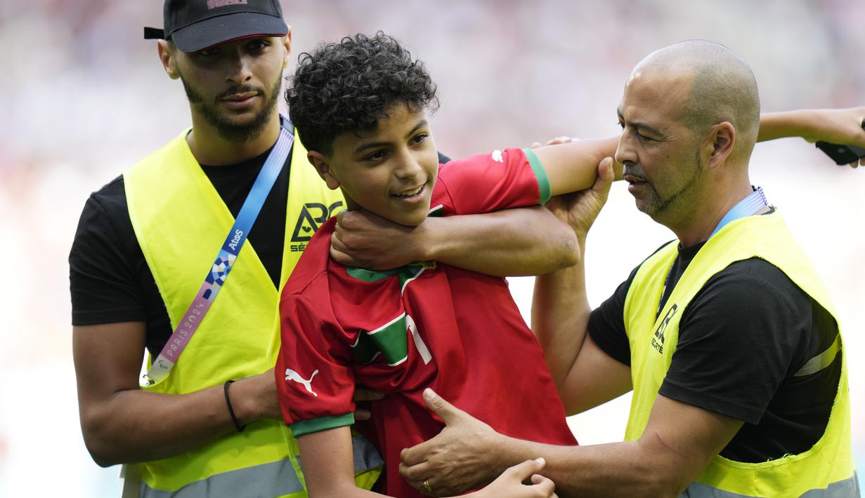 Hal tersebut memancing amarah para pendukung Maroko yang membuat mereka melempari berbagai obyek seperti gelas, botol hingga nekat menerobos lapangan. (AP Photo/Silvia Izquierdo)