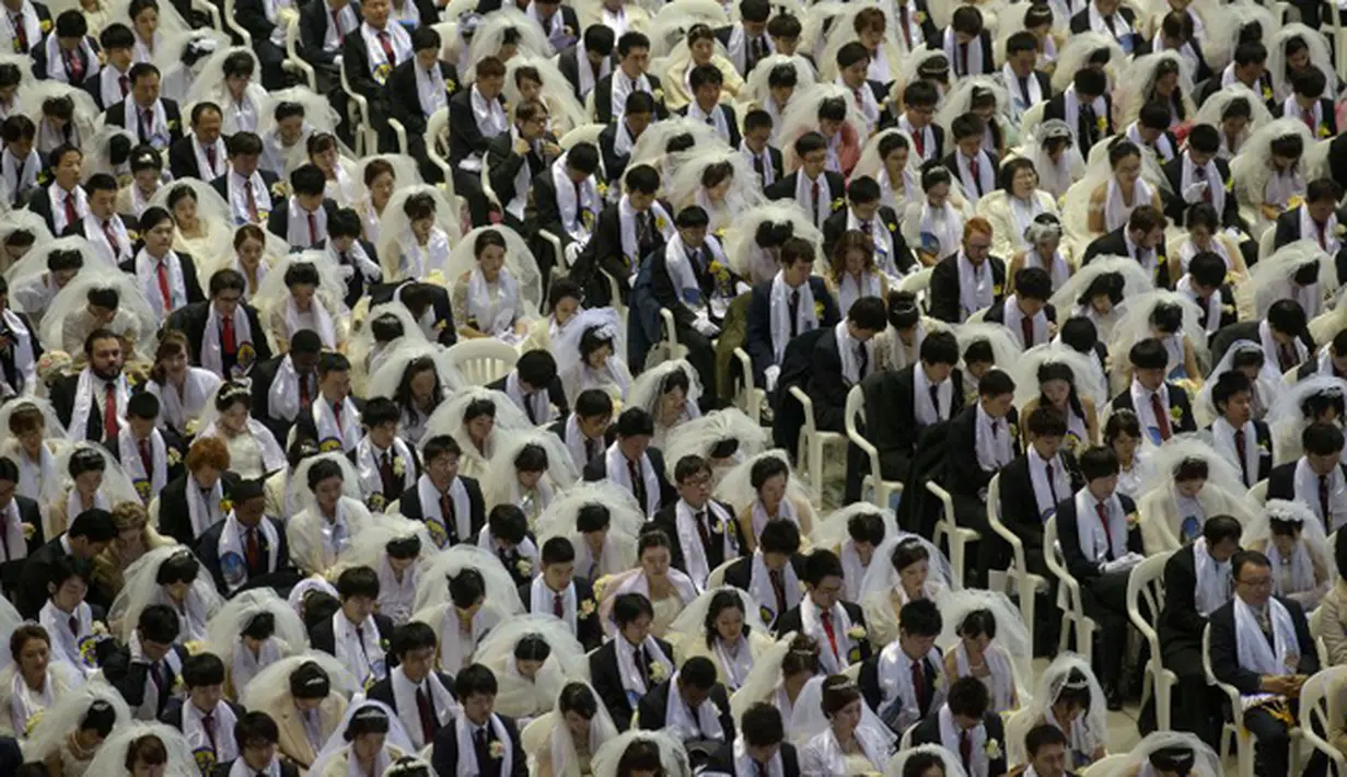 Ribuan pasangan pengantin berdoa selama pernikahan massal yang diselenggarakan oleh Gereja Unifikasi di Gapyeong di Gapyeong, Korea Selatan, Selasa (3/2/2015). (AFP PHOTO/Ed Jones)