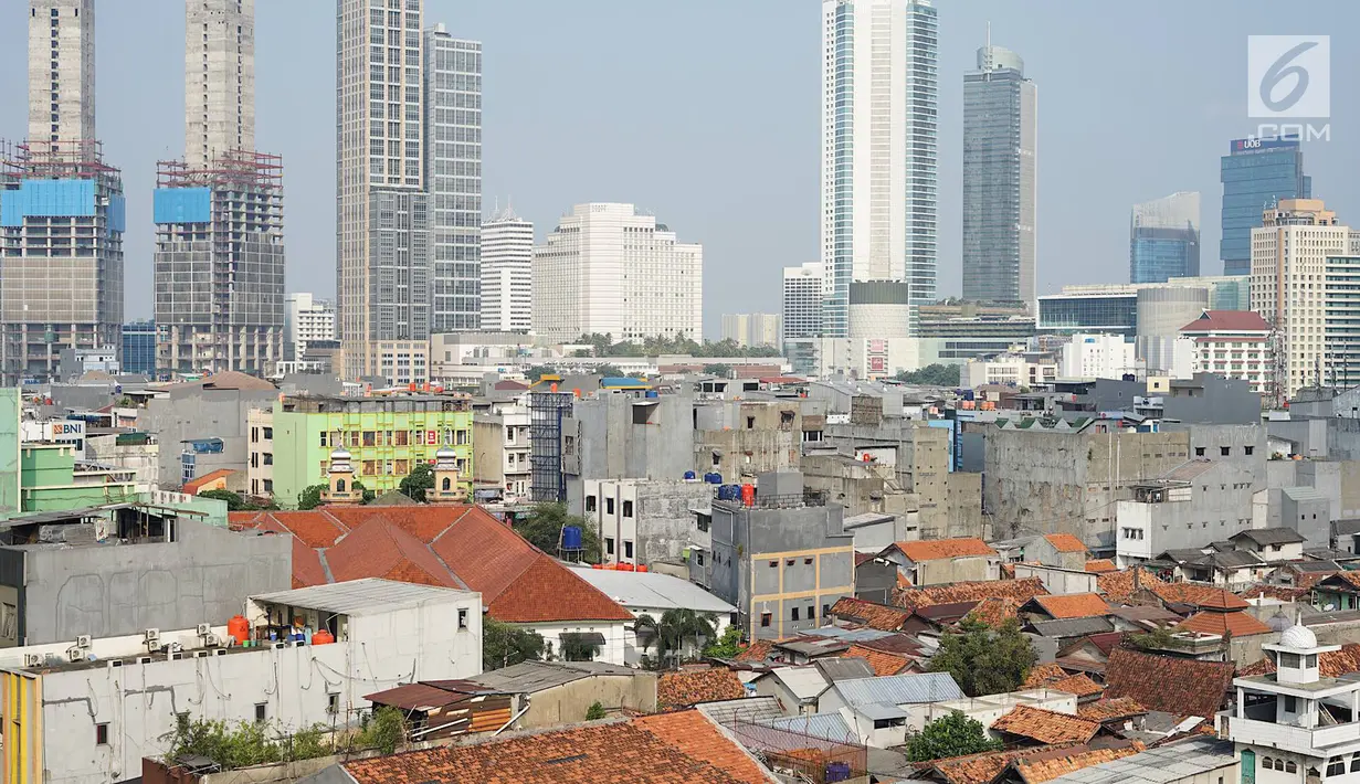 Lansekap pemukiman penduduk berlatar gedung bertingkat terlihat dari Tanah Abang, Jakarta, Selasa (21/5). Laporan Oxford Economics berjudul Global Cities 2018 menyebut Jakarta akan jadi kota dengan jumlah penduduk terbesar di dunia pada 2035, yakni 38 juta jiwa. (Liputan6.com/Immanuel Antonius)