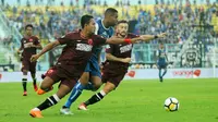 Penyerang Arema, Thiago Furtuoso, dikawal dua pemain PSM pada laga di Stadion Kanjuruhan, Malang, Minggu (13/5/2018). (Bola.com/Iwan Setiawan)