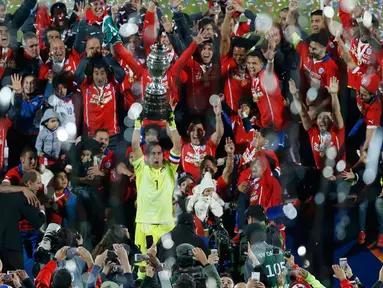 Kiper Chili, Claudio Bravo mengangkat trofi usai mengalahkan Argentina saat Final Copa America 2015  di Stadion Nasional, Santiago, Chili, (4/7/2015). Chili menang lewat adu penalti atas Argentina dengan skor 4-1. (REUTERS/Ueslei Marcelino)