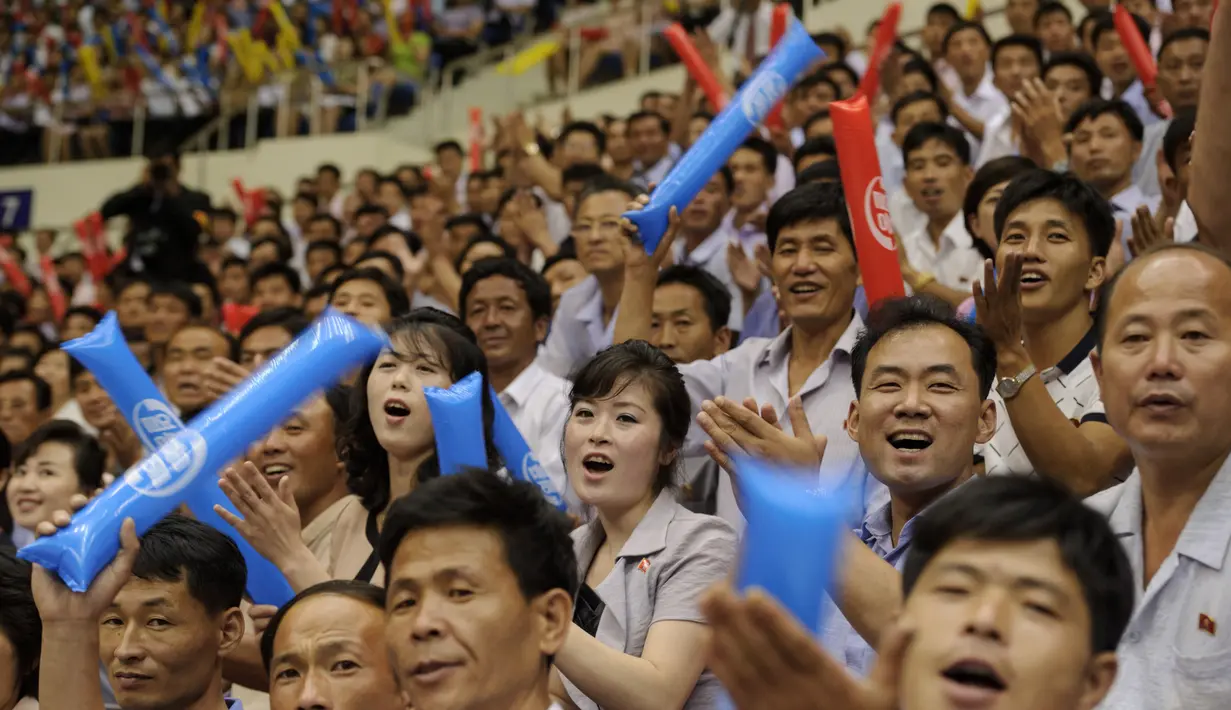 Fans Korea Utara saat menonton pertandingan antara Korea Utara dan Korea Selatan di Stadion Indoor Ryugyong Chung Ju-Yung, Pyongyang (5/7). 50 pemain pria dan wanita dari Korsel tiba di ibukota Utara 3 Juli untuk laga persahabatan. (AFP Photo/Kim Won-Jin)