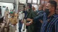 Anggota DPRD Sikka Fransiskus Cinde mengenakan baju safari berwarna hijau tua, sedang mengamuk dan dilerai oleh anggota DPRD Sikka. (Liputan6.com/Dionisius Wilibardus)