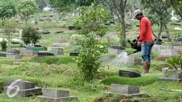 Penjaga menyirami makam di Tempat Pemakaman Umum (TPU) Karet Bivak, Jakarta, Rabu (13/7). Sudin Pertamanan dan Pemakaman Jakarta Pusat akan buat ratusan lubang biopori di TPU Karet Bivak agar makam tidak tergenang saat hujan. (Liputan6.com/Yoppy Renato)