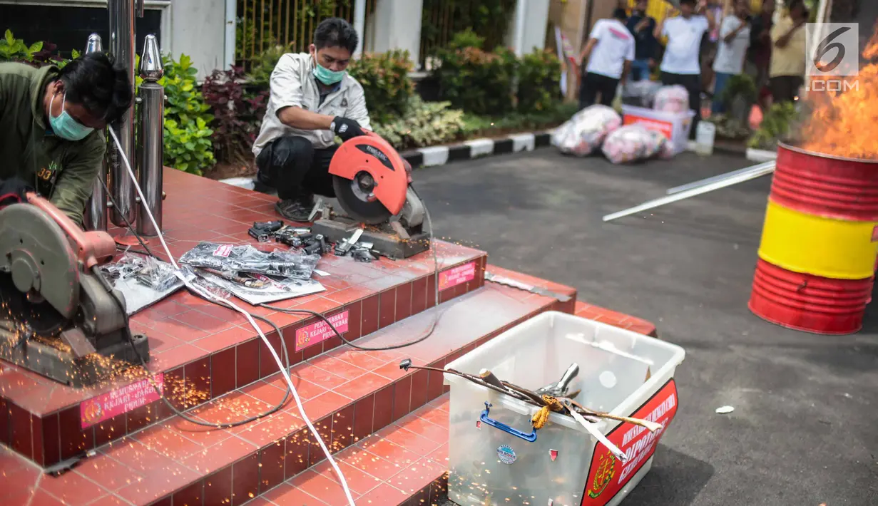 Petugas memusnahkan barang bukti berupa senjata api di lapangan Kejaksaan Negeri Jakarta Barat, Selasa (11/12). Pemusnahan barang bukti merupakan bentuk keseriusan penegak hukum dalam pengentasan kasus-kasus kejahatan. (Liputan6.com/Faizal Fanani)